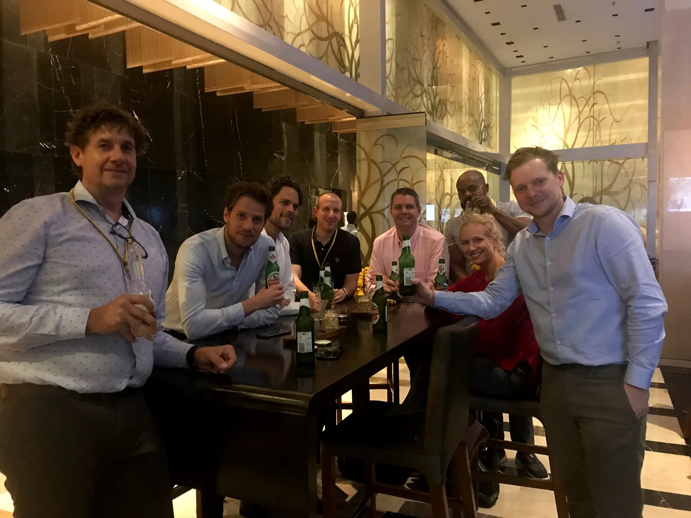 Een gezamenlijke ontmoeting met een team, rond een hoge tafel met drankjes.